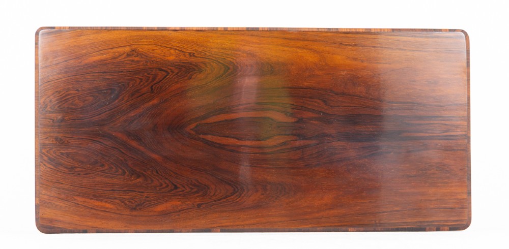 A mid-19th century Victorian rosewood stretcher table featuring a rectangular polished top, openwork pierced end supports, a turned central stretcher, and brass castors. View VIII
