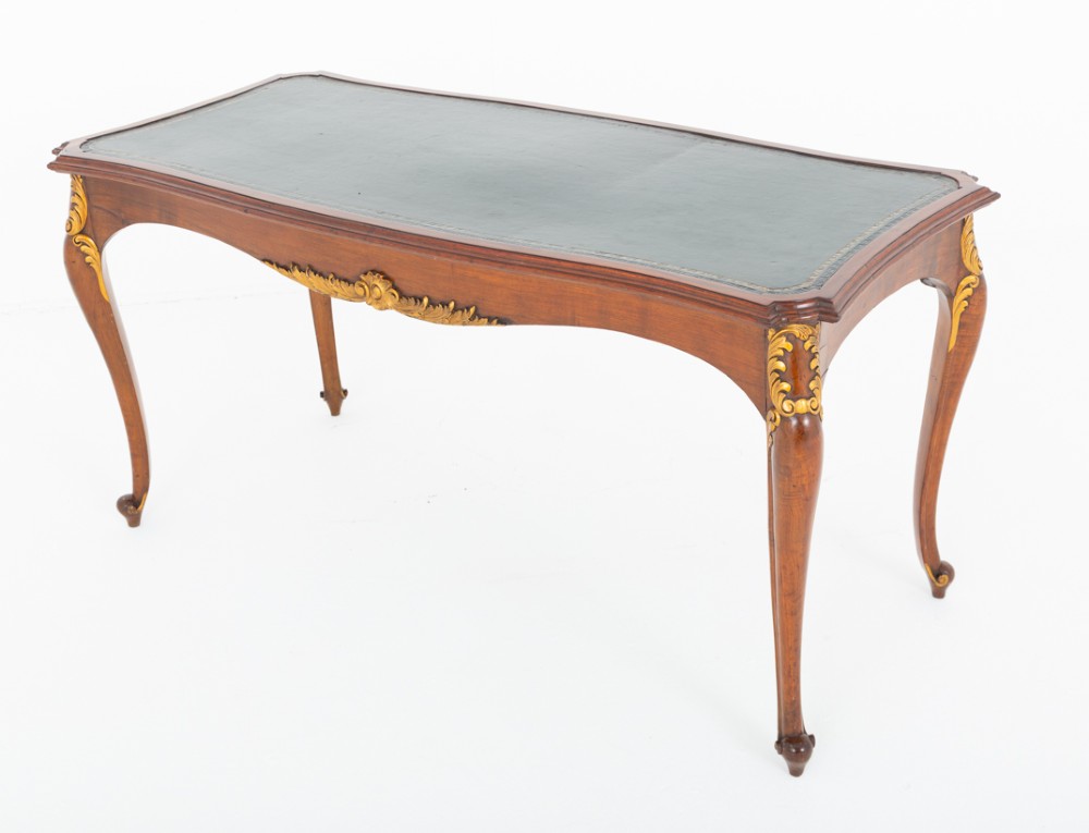 A mahogany centre writing table with cabriole legs, gilded rococo mounts on the frieze and knees, and a dark green leather inset surface.