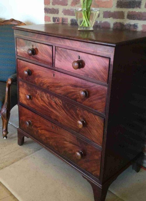 fig 1. A Victorian mahogany chest of drawers featuring flame mahogany veneer fronts, turned handles, and a two-short-over-three-long drawer layout on bracket feet.