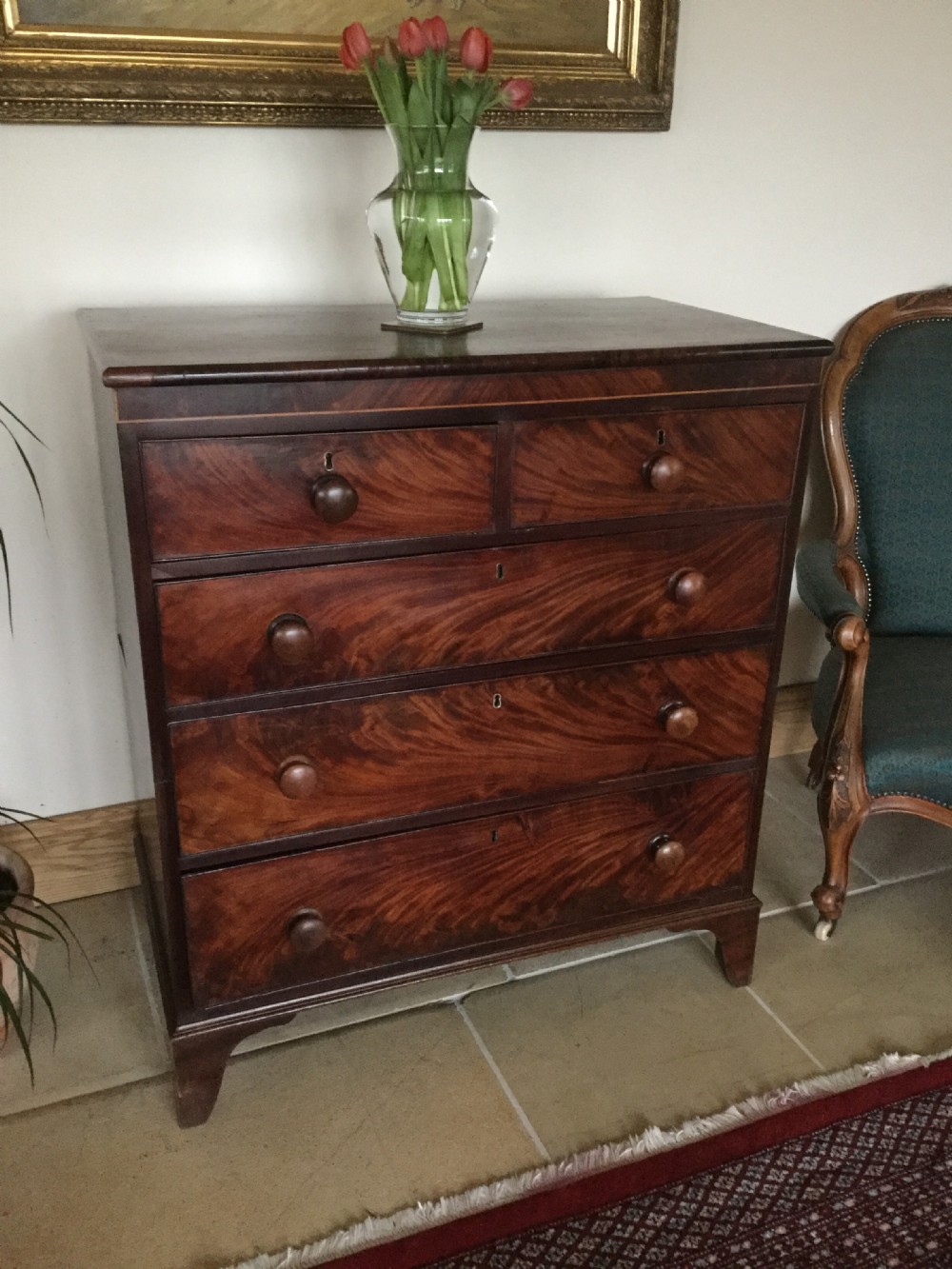 A Victorian mahogany chest of drawers featuring flame mahogany veneer fronts, turned handles, and a two-short-over-three-long drawer layout on bracket feet. View III