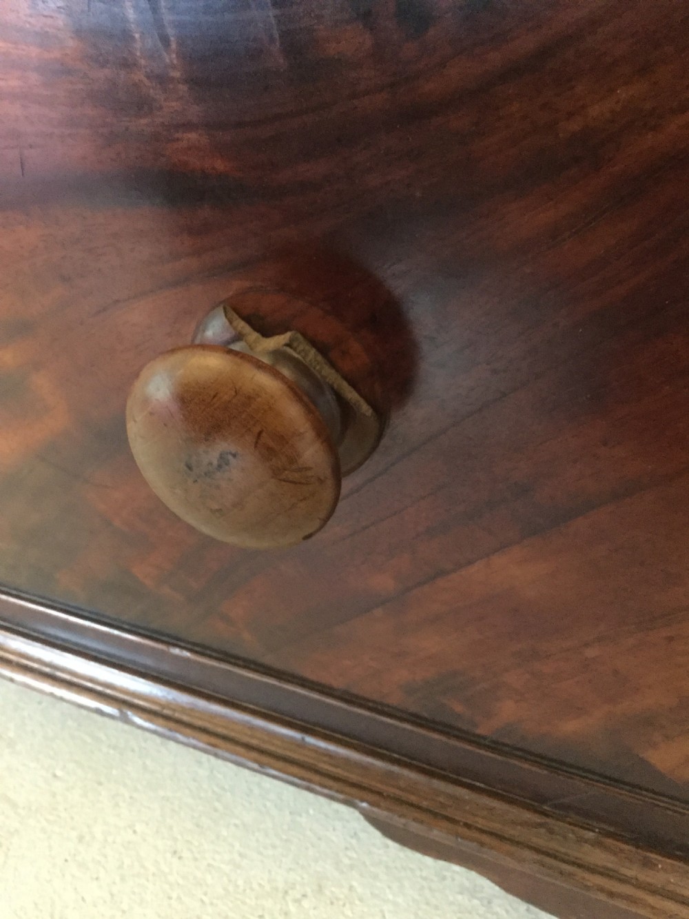 A Victorian mahogany chest of drawers featuring flame mahogany veneer fronts, turned handles, and a two-short-over-three-long drawer layout on bracket feet. View XIII