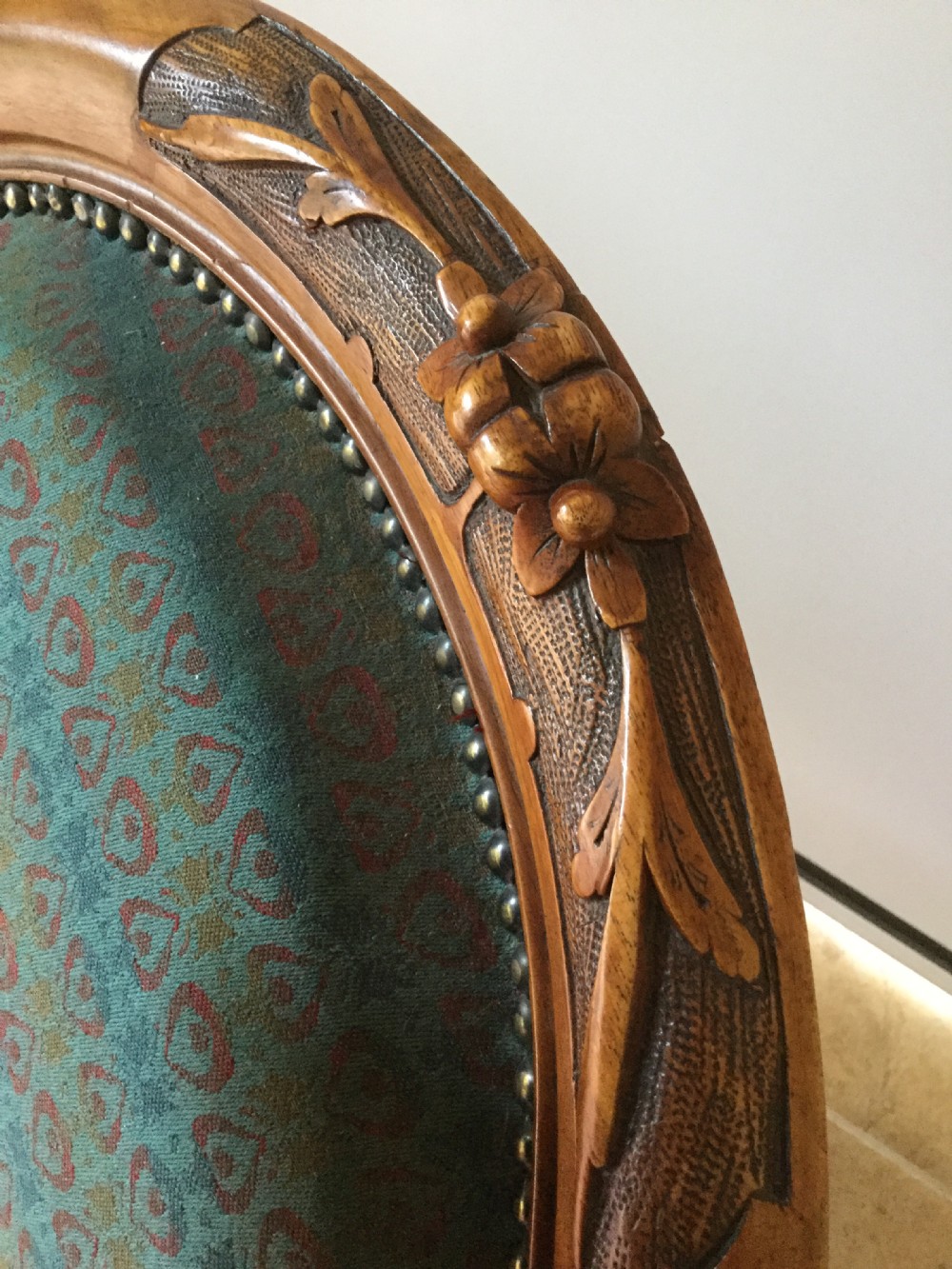 A Victorian carved walnut open armchair upholstered in patterned teal fabric with cabriole legs and front castors. View VIII
