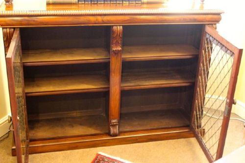 A 19th-century dark rosewood chiffonier cabinet featuring a raised top shelf on turned columns and two doors with brass wire lattice grilles. View VI