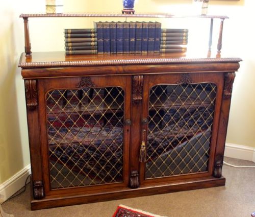 A 19th-century dark rosewood chiffonier cabinet featuring a raised top shelf on turned columns and two doors with brass wire lattice grilles. View VII