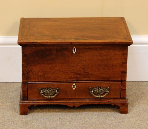 A 19th-century miniature walnut mule chest featuring visible dovetail joinery, a hinged top lid, a single lower drawer with decorative brass handles, and bone keyhole escutcheons. View II