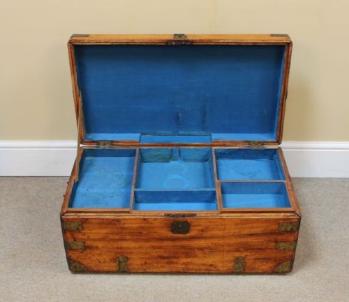 A nineteenth-century rectangular camphor wood chest featuring brass corner brackets, protective brass strapping, and a central keyhole escutcheon. View V
