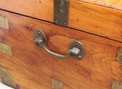 A nineteenth-century rectangular camphor wood chest featuring brass corner brackets, protective brass strapping, and a central keyhole escutcheon. View VIII