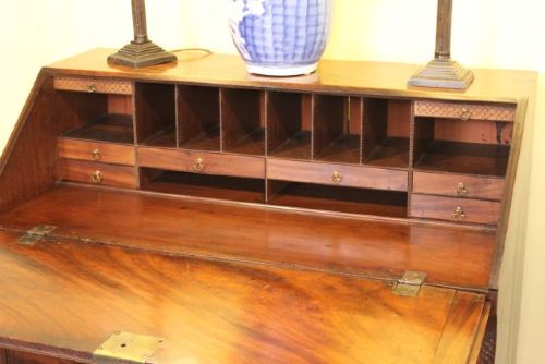 An 18th-century Georgian flame mahogany bureau featuring a sloping fall-front lid, four graduated drawers with brass handles, and ogee bracket feet. View III