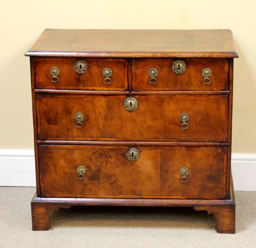 An 18th-century Georgian walnut chest of drawers featuring two short over two long drawers with brass drop handles and bracket feet. View II