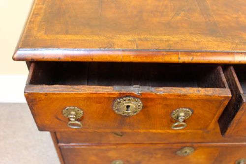 An 18th-century Georgian walnut chest of drawers featuring two short over two long drawers with brass drop handles and bracket feet. View VI