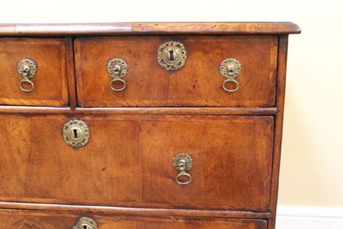 An 18th-century Georgian walnut chest of drawers featuring two short over two long drawers with brass drop handles and bracket feet. View VII