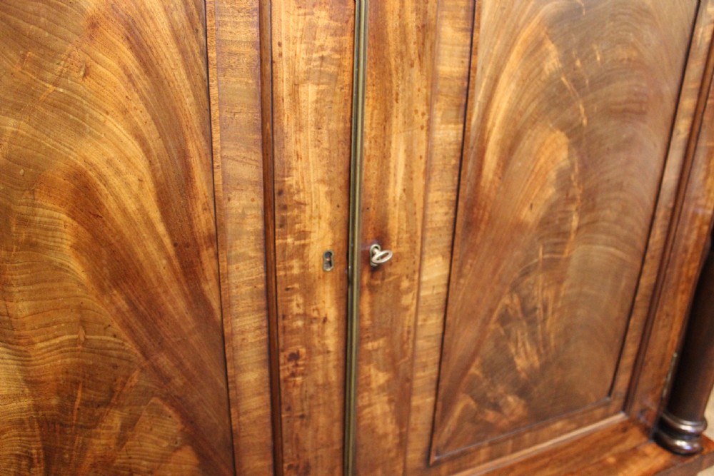 A nineteenth-century mahogany chiffonier featuring a upper shelf gallery on turned supports above a two-door cabinet with flame mahogany veneer panels. View VI