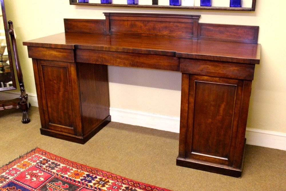 A nineteenth-century mahogany pedestal sideboard featuring twin cupboard bases, a recessed central drawer section, and a stepped backboard. View III