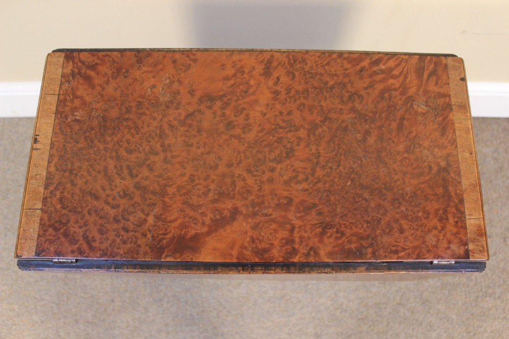 A nineteenth-century amboyna and walnut occasional table featuring rich burr graining, a rectangular top, and turned legs joined by a cross-stretcher. View II