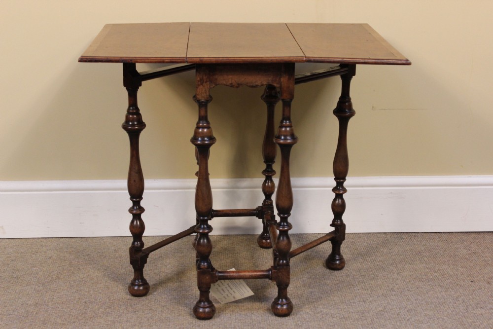 A nineteenth-century amboyna and walnut occasional table featuring rich burr graining, a rectangular top, and turned legs joined by a cross-stretcher. View IV