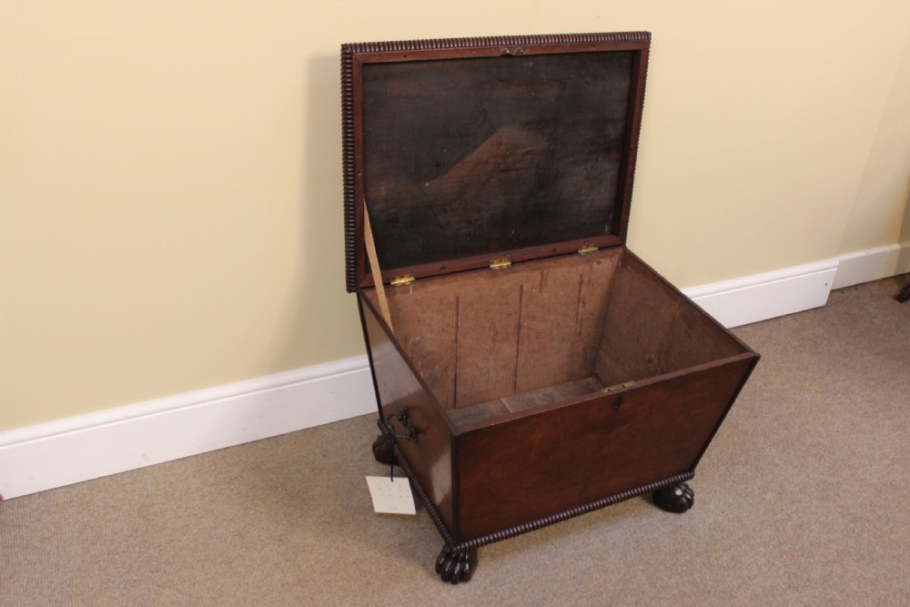 A nineteenth-century mahogany sarcophagus-shaped cellarette featuring reeded moulding borders, a keyhole escutcheon, and carved paw feet. View IV