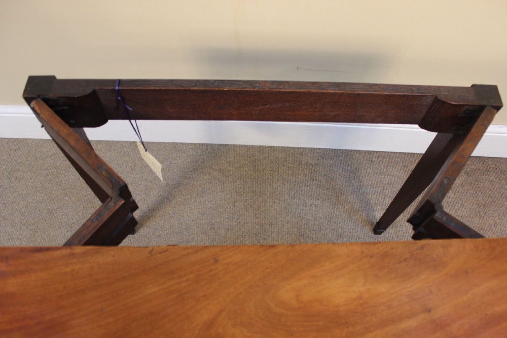 An early 19th-century mahogany fold-over card table featuring a shaped top, flame mahogany veneers, and fluted tapered legs adorned with carved rosettes. View V