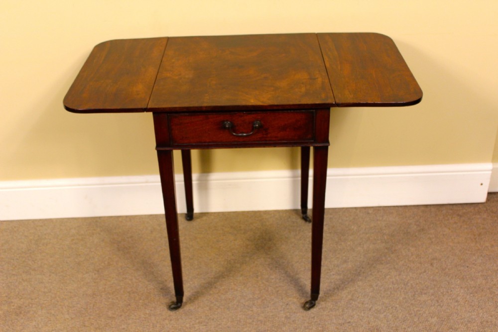 An 18th-century mahogany Pembroke side table featuring drop leaves, a single front drawer with brass pull, and tapered square legs on brass castors. View V