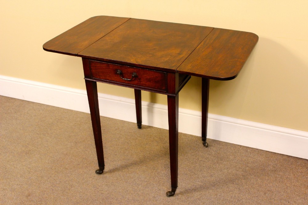 An 18th-century mahogany Pembroke side table featuring drop leaves, a single front drawer with brass pull, and tapered square legs on brass castors. View VI