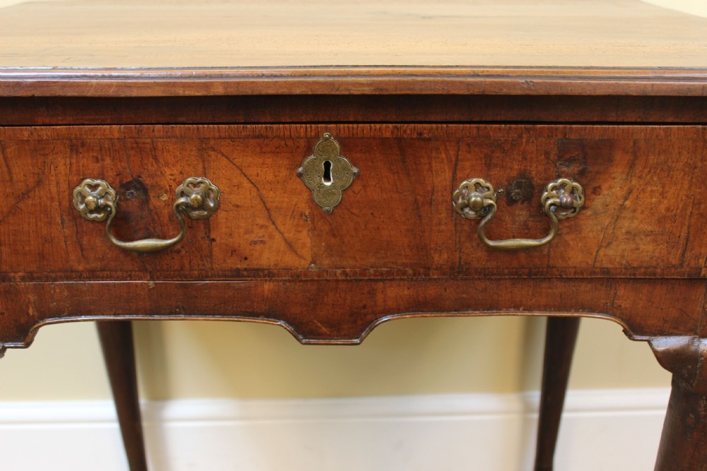 An 18th-century walnut lowboy featuring a single drawer with brass handles, cabriole legs, pad feet, and a shaped apron. View III