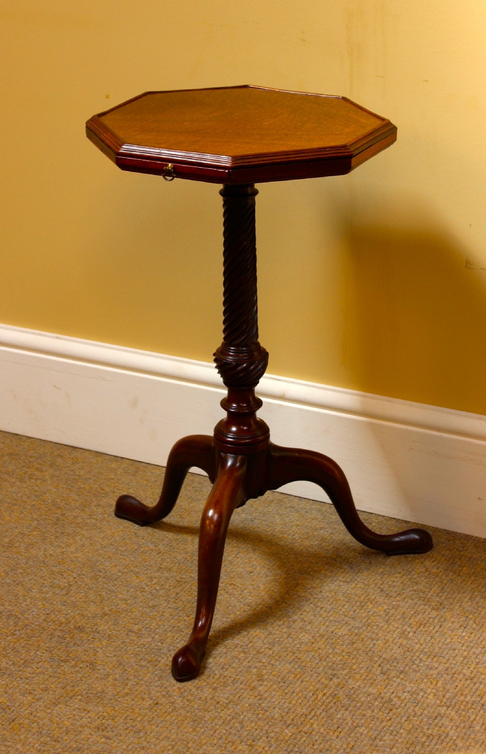 An octagonal mahogany George III kettle stand featuring a barley-twist column and tripod cabriole legs.