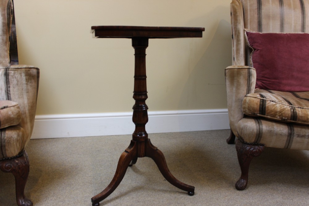 A nineteenth-century dark rosewood tripod table featuring a square top with rounded corners, a central turned pedestal, and three splayed feet. View II