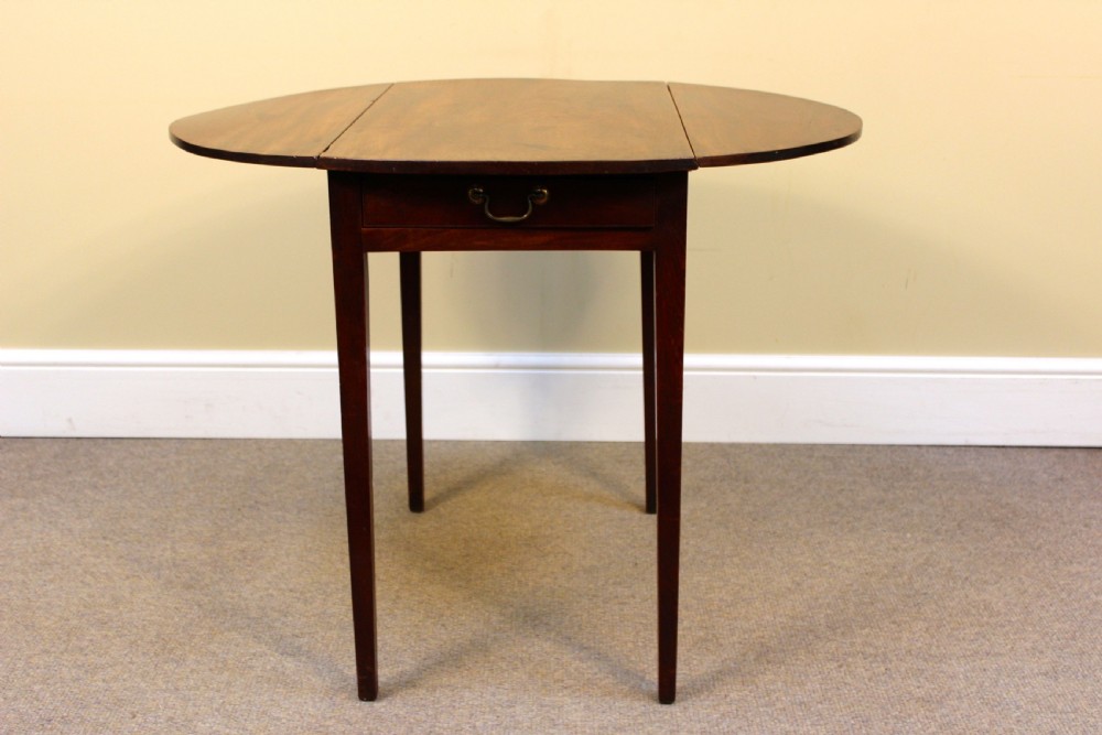 A rectangular Georgian mahogany Pembroke table featuring two drop leaves and tapered legs stands against a neutral background. View III