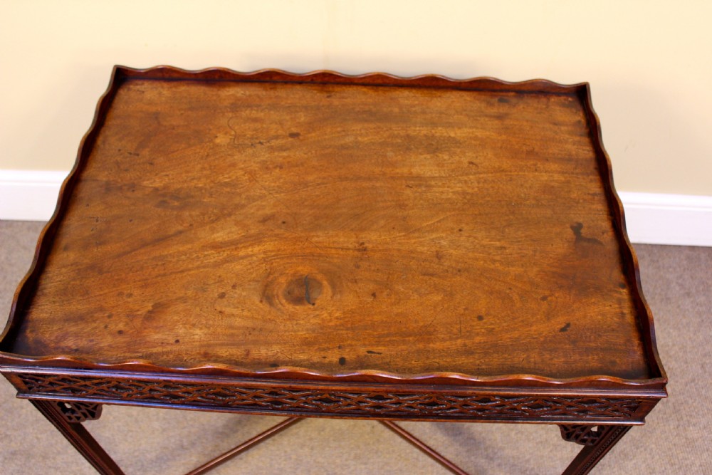 A late 18th-century mahogany silver table featuring a scalloped gallery rim, carved fretwork apron, corner brackets, and an X-shaped stretcher joining four straight legs. View II