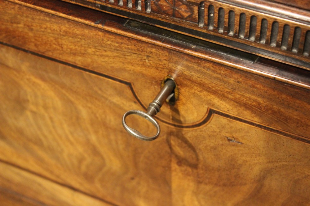 A late 18th-century mahogany secretaire chest on chest featuring flame mahogany veneer, brass swan-neck handles, a decorative blind-fret cornice, and bracket feet. View VIII