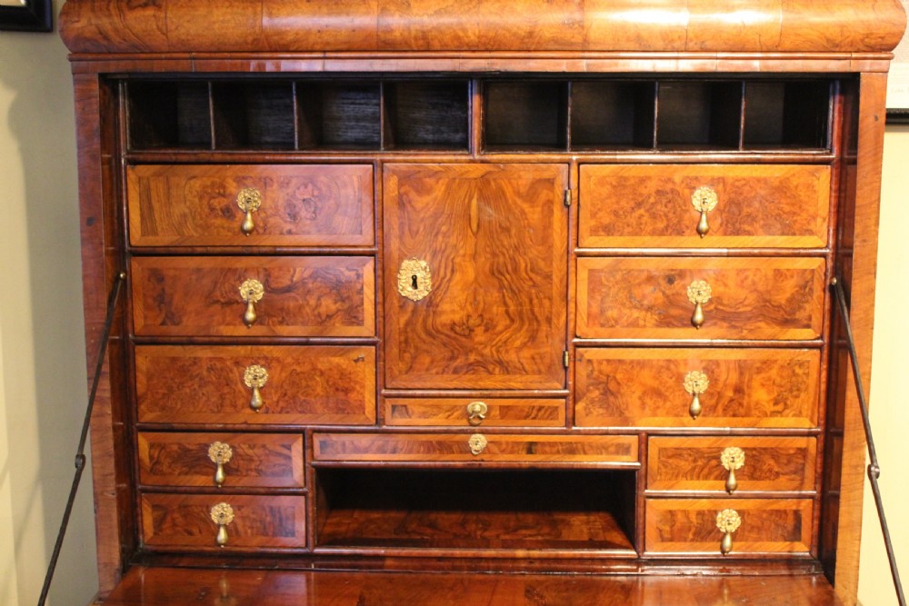 An early eighteenth-century walnut escritoire featuring a fall-front writing upper section with cushion moulding over a chest of three long drawers on bracket feet. View IV