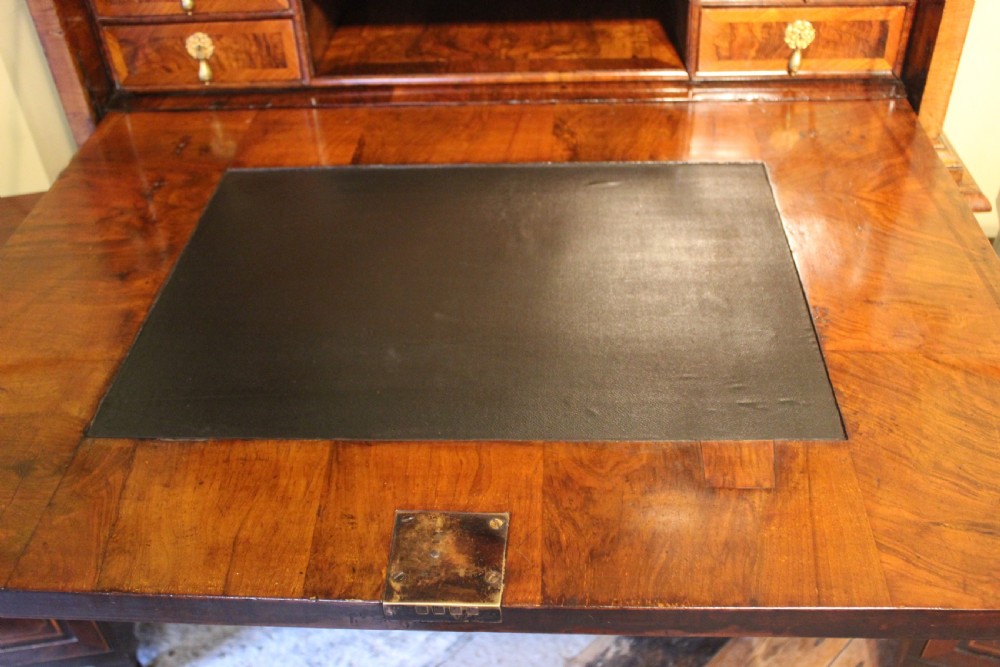 An early eighteenth-century walnut escritoire featuring a fall-front writing upper section with cushion moulding over a chest of three long drawers on bracket feet. View VI