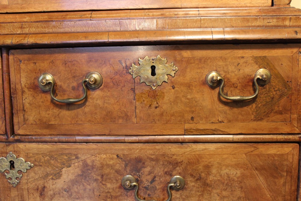 An early eighteenth-century walnut escritoire featuring a fall-front writing upper section with cushion moulding over a chest of three long drawers on bracket feet. View IX