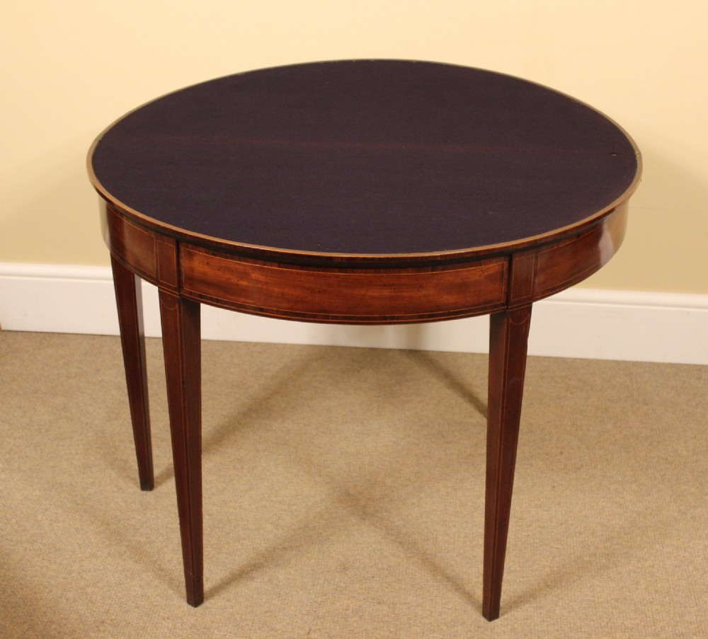 A nineteenth-century mahogany demi-lune card table featuring linear string inlay and square tapered legs. View IV