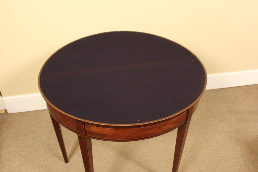 A nineteenth-century mahogany demi-lune card table featuring linear string inlay and square tapered legs. View V