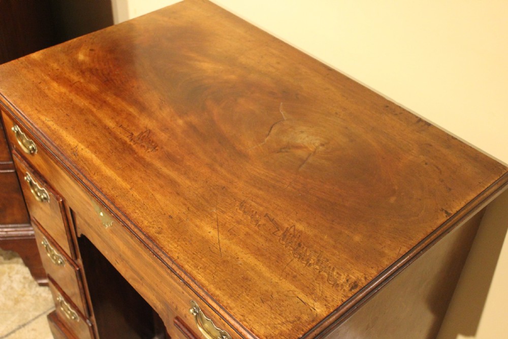 An 18th-century mahogany kneehole desk featuring a long upper drawer, six pedestal drawers, a central cupboard, and brass hardware. View II