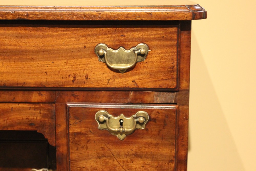 An 18th-century mahogany kneehole desk featuring a long upper drawer, six pedestal drawers, a central cupboard, and brass hardware. View III