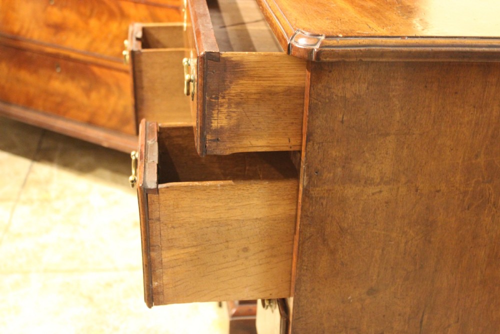 An 18th-century mahogany kneehole desk featuring a long upper drawer, six pedestal drawers, a central cupboard, and brass hardware. View VIII