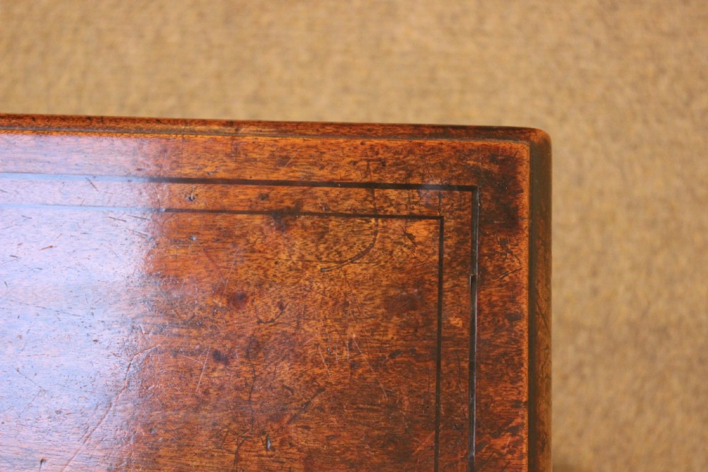 A long rectangular dark mahogany coffee table featuring a polished surface, shaped aprons with circular brass rosette mounts, and four square tapered legs. View IV