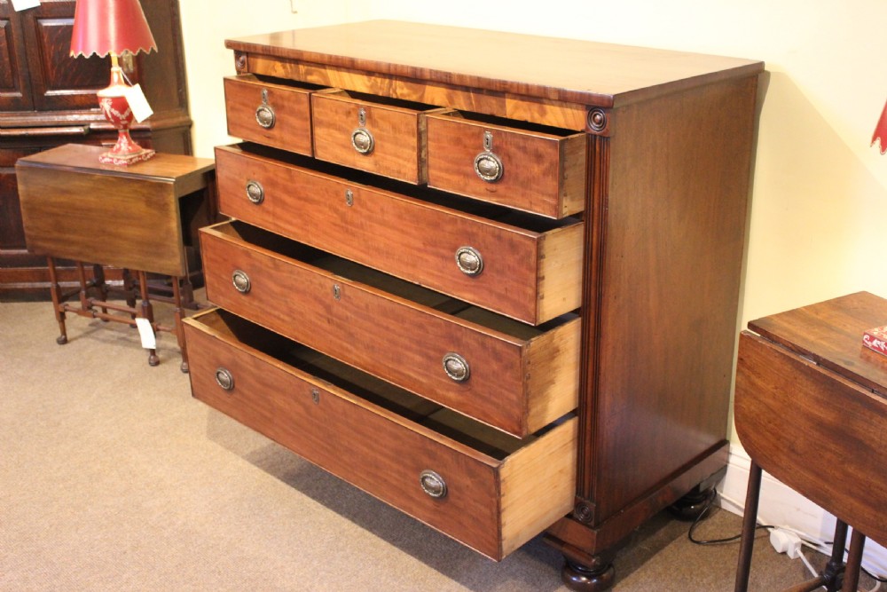 A nineteenth-century Scottish mahogany chest of drawers featuring three upper drawers over three long graduated drawers with reeded side columns and turned feet. View III