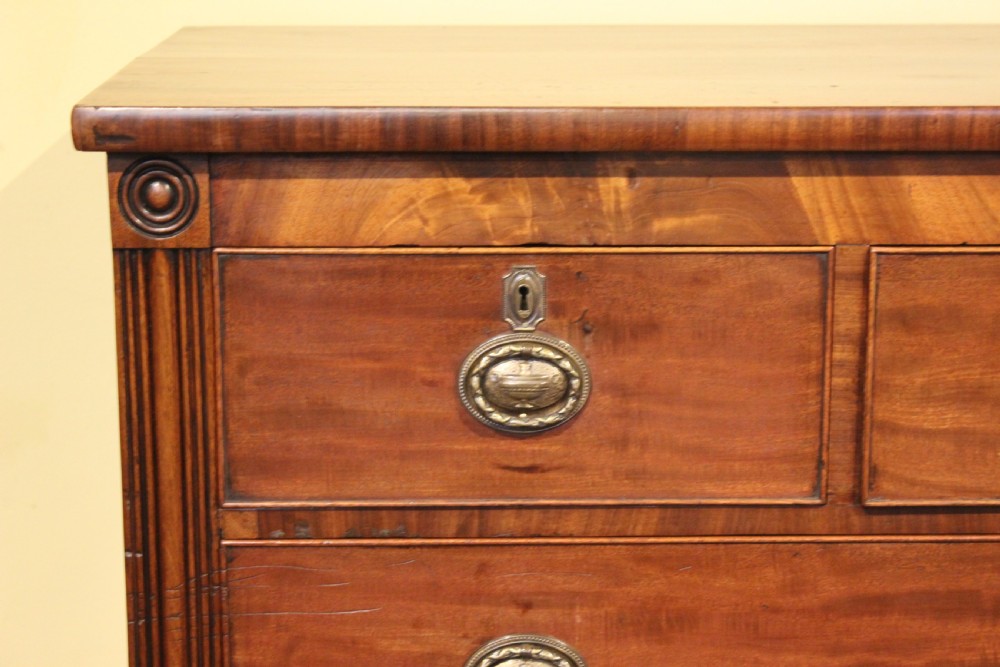 A nineteenth-century Scottish mahogany chest of drawers featuring three upper drawers over three long graduated drawers with reeded side columns and turned feet. View V