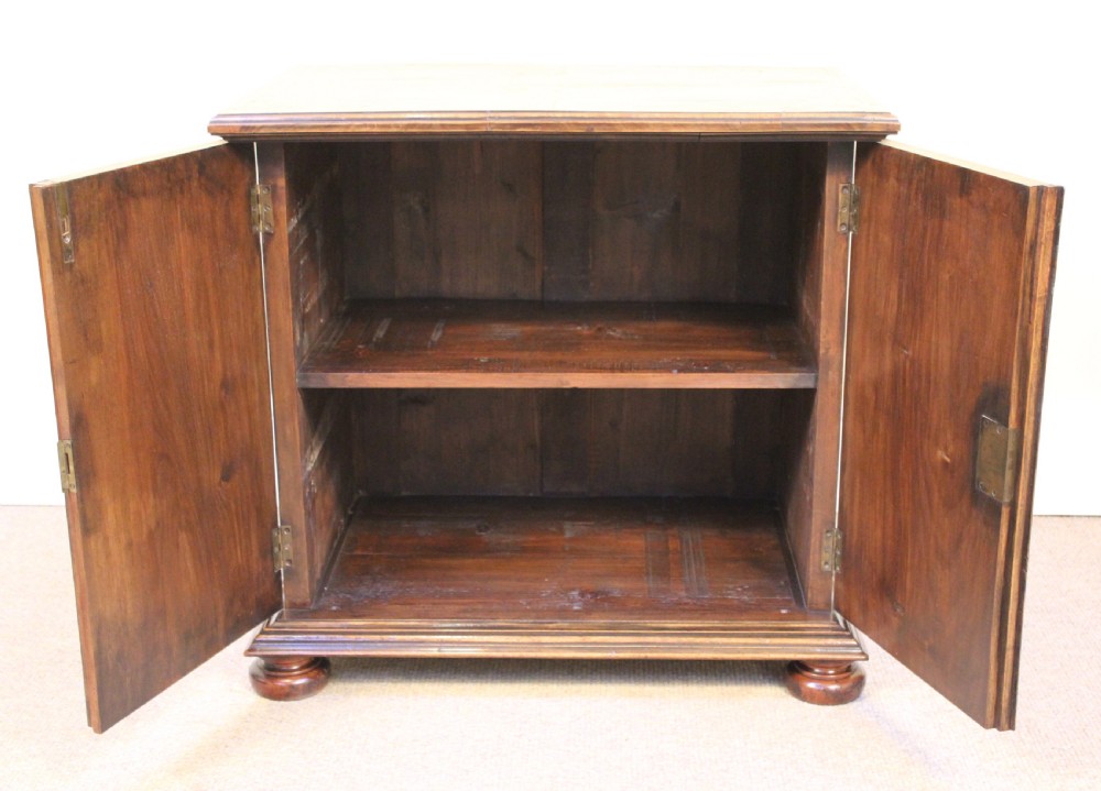 A 19th-century walnut side cabinet featuring twin book-matched veneer doors, moulded base, and turned bun feet. View II