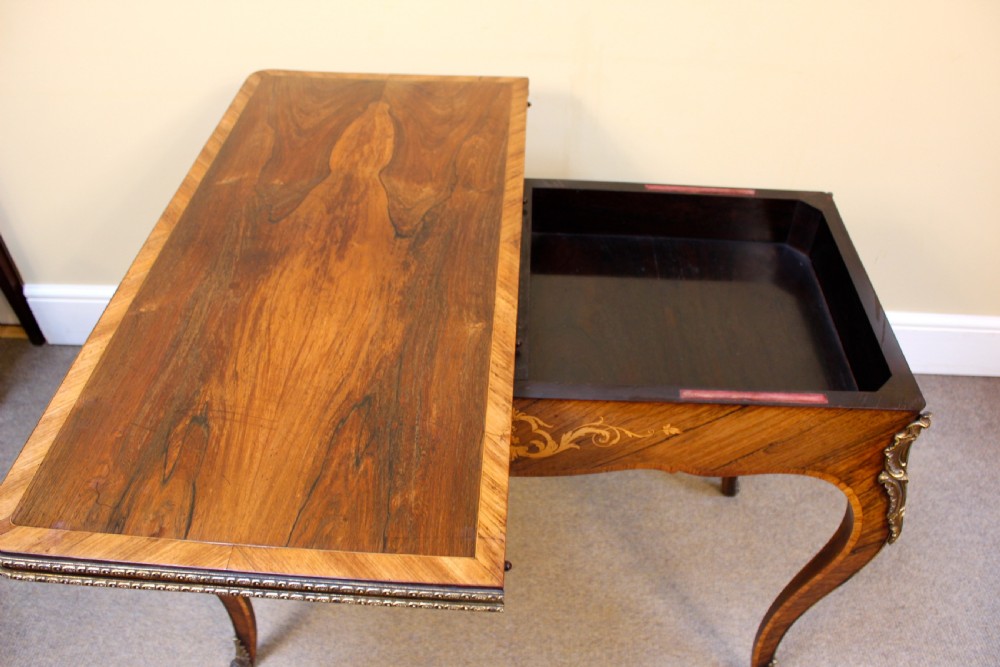 A 19th-century rosewood card table featuring kingwood crossbanding, central marquetry inlay, cabriole legs, and brass shoulder mounts. View VI