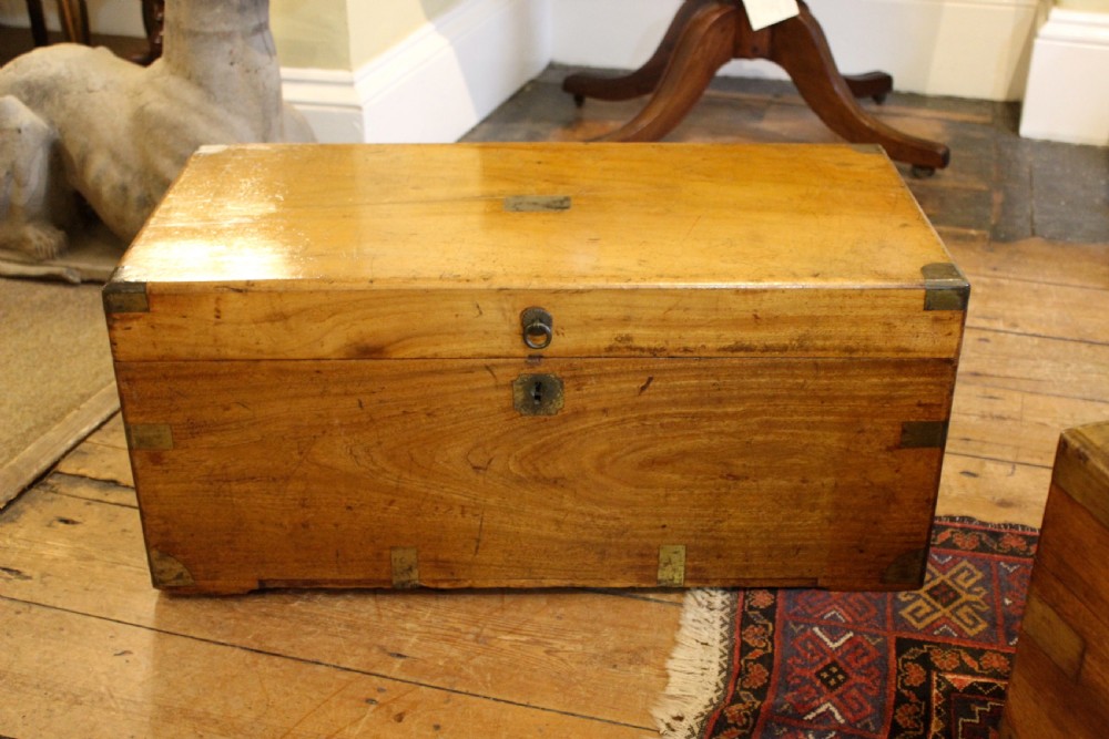 A nineteenth-century rectangular camphor wood chest featuring flush-mounted brass corner brackets, a central keyhole plate, and an overhead lid.