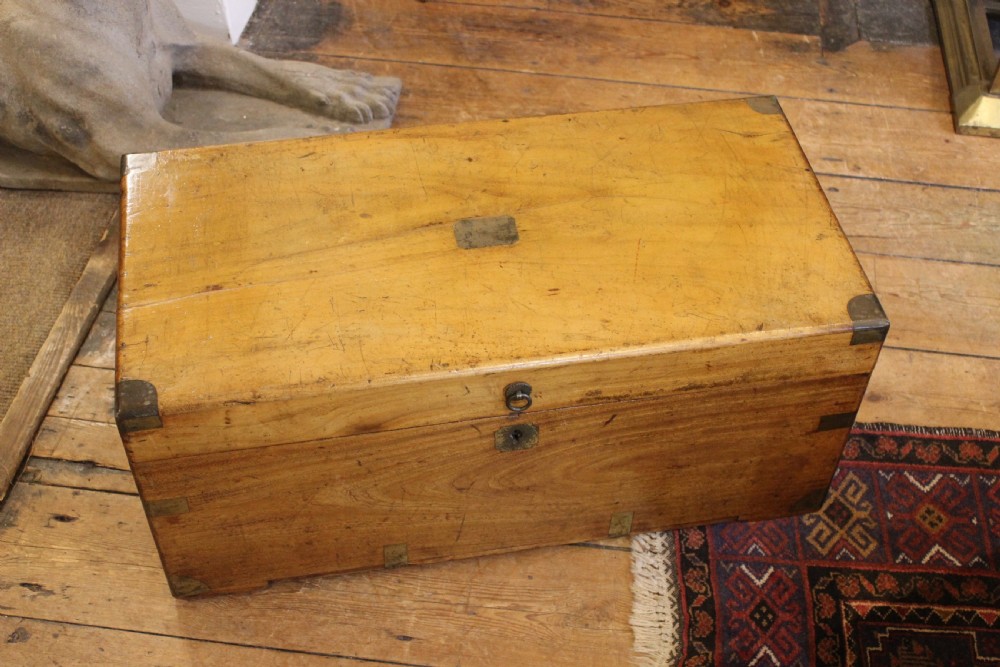 A nineteenth-century rectangular camphor wood chest featuring flush-mounted brass corner brackets, a central keyhole plate, and an overhead lid. View IV