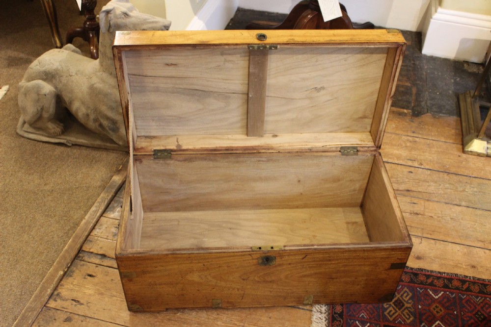 A nineteenth-century rectangular camphor wood chest featuring flush-mounted brass corner brackets, a central keyhole plate, and an overhead lid. View V
