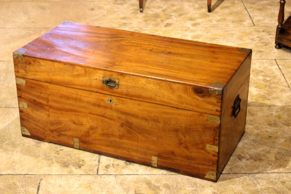 A rectangular 19th-century camphor wood chest featuring brass corner brackets, brass strap reinforcements, a central keyhole escutcheon, and dovetail joinery. View III