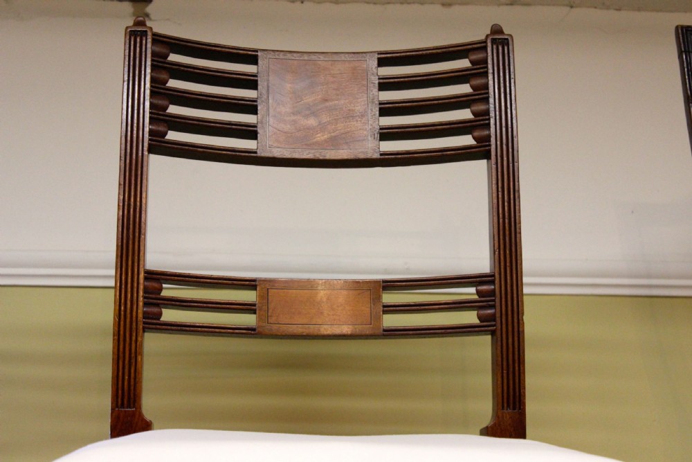 A set of nineteenth-century mahogany dining chairs featuring slatted backs with marquetry inlay panels and cream fabric seats. View IV