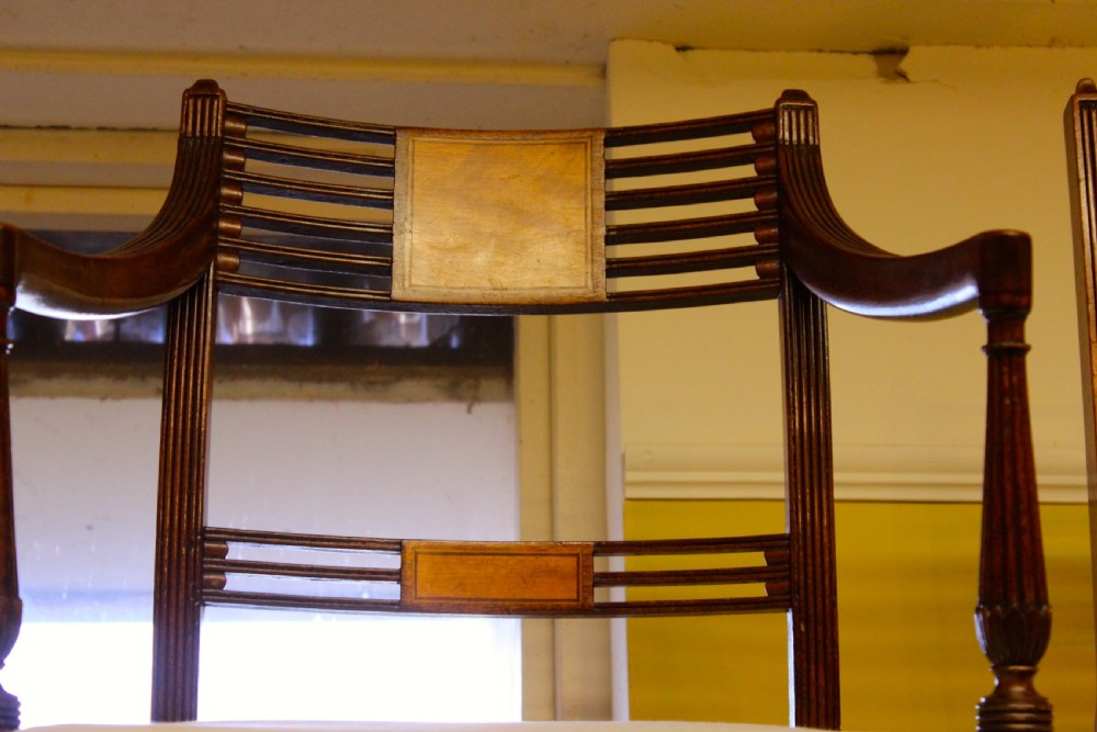 A set of nineteenth-century mahogany dining chairs featuring slatted backs with marquetry inlay panels and cream fabric seats. View V