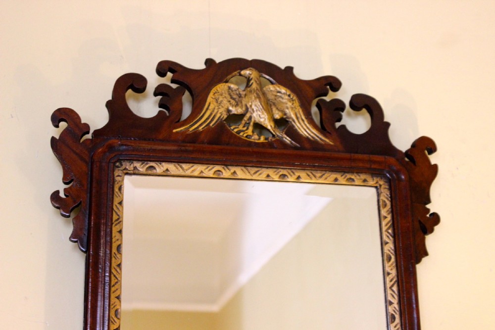 A 19th-century dark walnut fretwork wall mirror featuring scrolled timber edges, a gilded inner slip, and a carved gilt eagle crest at the top. View III