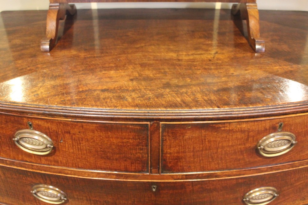 A nineteenth-century mahogany bow-fronted chest of drawers featuring two short and three long drawers with oval brass handles. View III